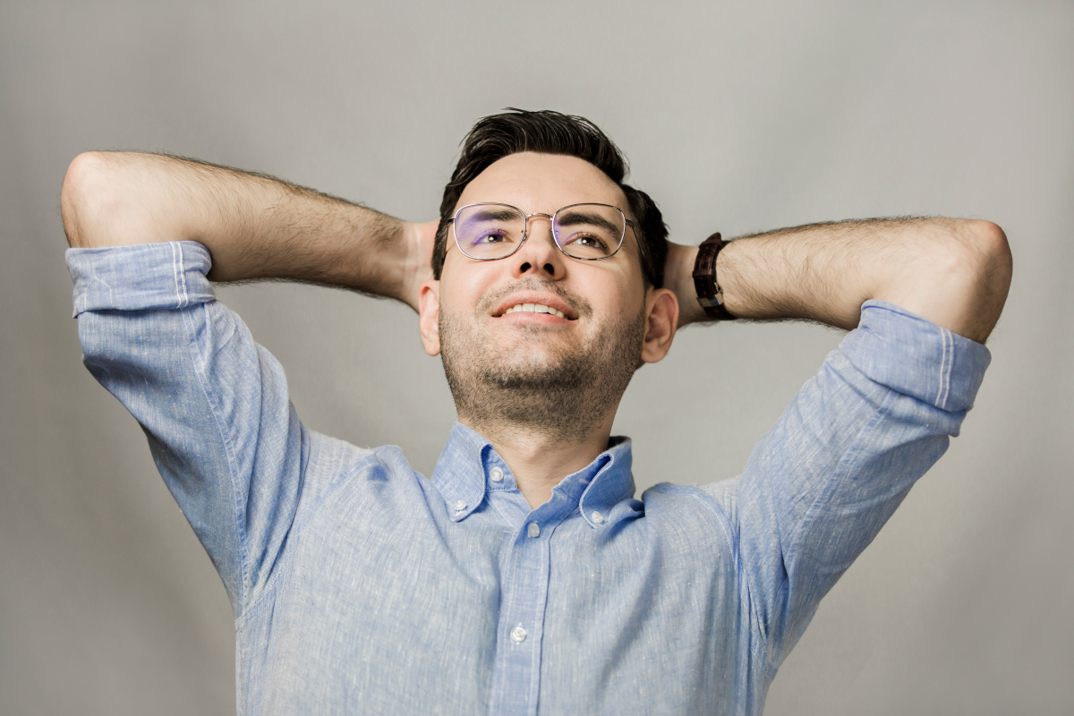 Wojtek Wawrzak - radca prawny, założone ręce za głową symbolizujące spokój